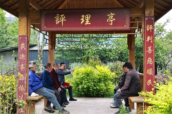 余廷学在评理亭里收集群众建议意见